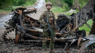 Украинский солдат возле останков российской военной техники. Лето 2022 года