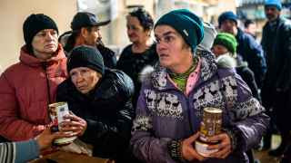 Местные жители получают еду в пункте гуманитарной помощи