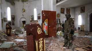 13 января Россия заявила, что захватила Соледар, город на востоке Украины. Это стало ее первой победой за несколько месяцев боевых действий. На фото наемник группы «Вагнера» входит в Спасо-Преображенскую церковь Соледара после сильного пожара.