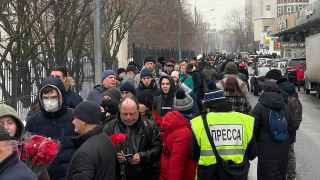 Люди выстраиваются в очередь возле храма.