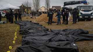 Украина. Буча. Работники кладбища и сотрудники полиции возле тел, извлеченных из массового захоронения.
