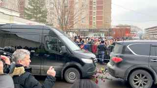 Катафалк отъезжает от церкви на кладбище.