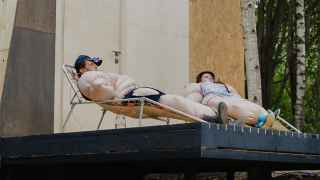 Московский уличный художник Алексей Лука создал дом из различных уличных материалов, который лениво опирается на край оврага.