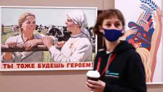 Посетительница форума перед плакатом советских времен.